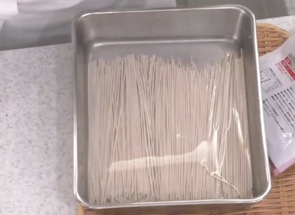 乾麺のそばをバットで見ずに浸けている画像