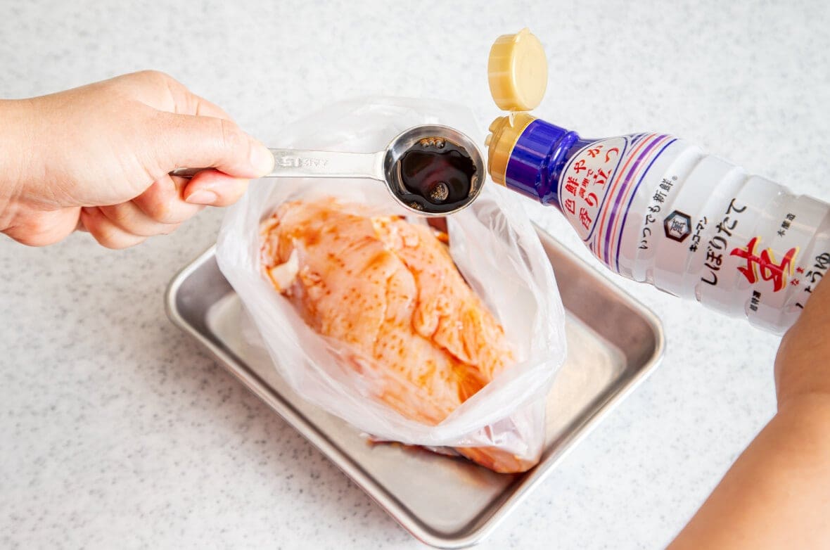 写真：鶏肉をポリ袋に入れて、しょうゆを加える