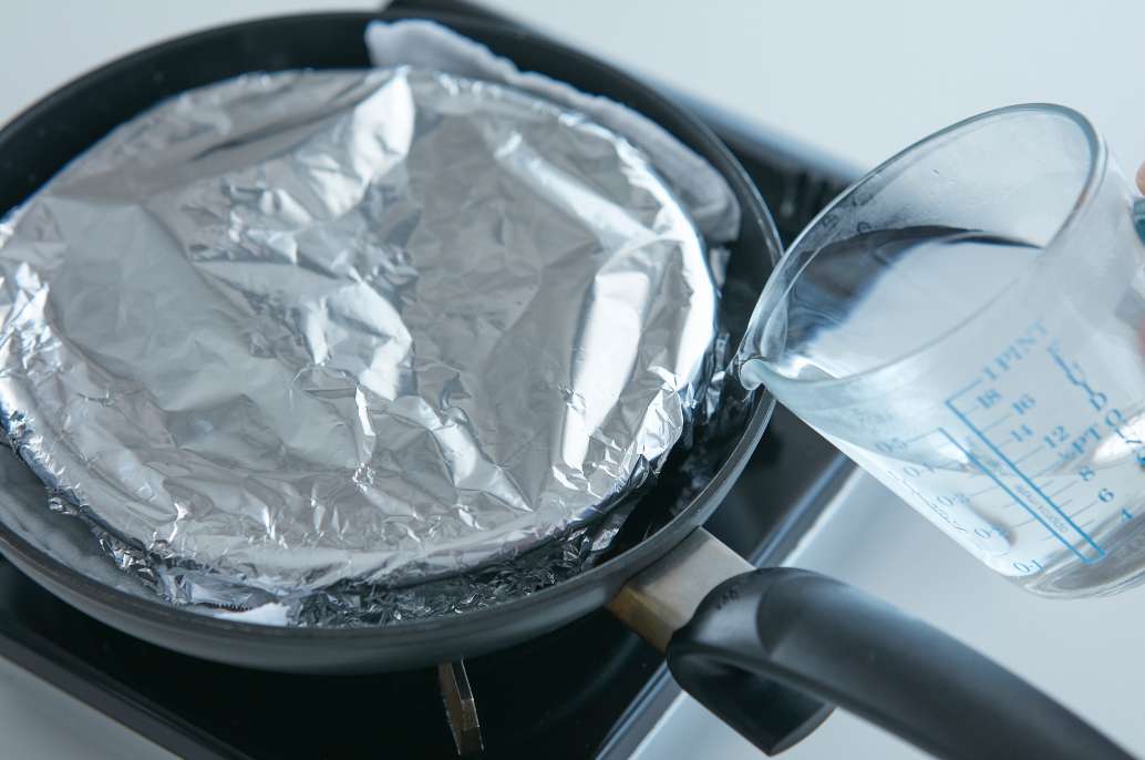 フライパンに耐熱容器をのせ、湯を注ぐ