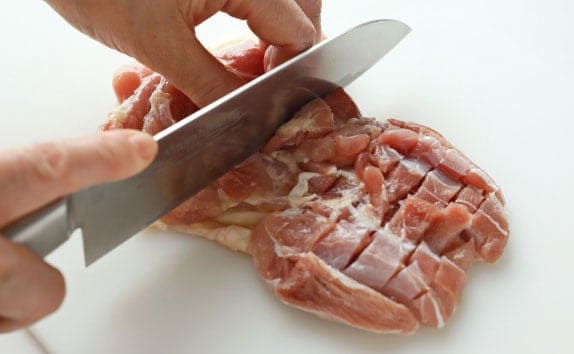 鶏肉は余分な脂を除き、身の方に1cm幅に切り込みを入れ、4等分に切る。