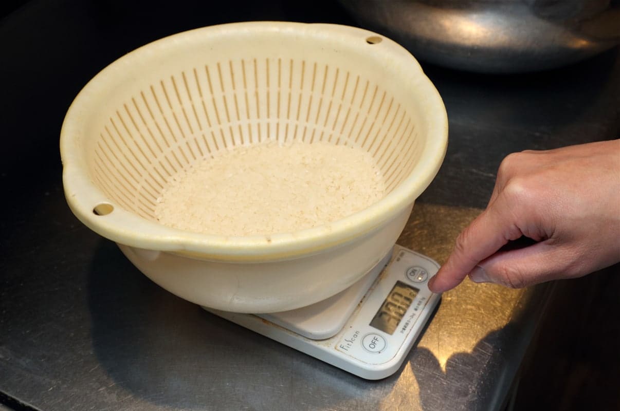 手順1：お米をざるなどに入れ、キッチンスケールで量る
