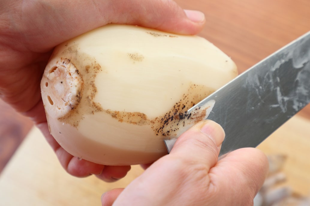 写真：くぼみ部分の皮は、包丁の根元で取り除く