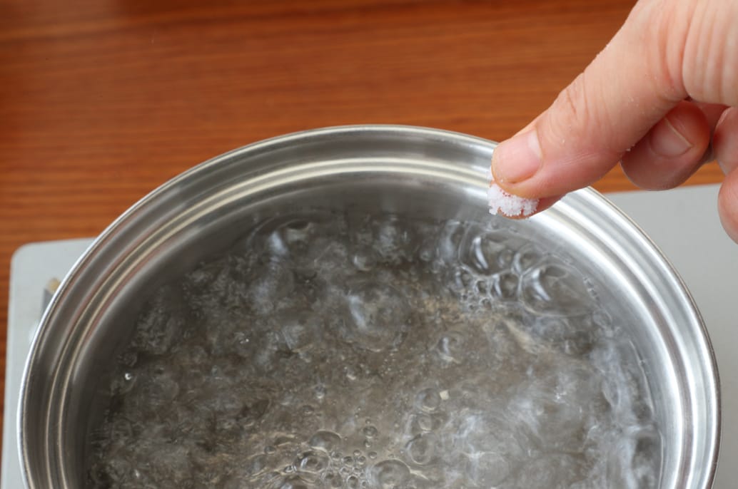 写真：沸騰したお湯に塩を入れる