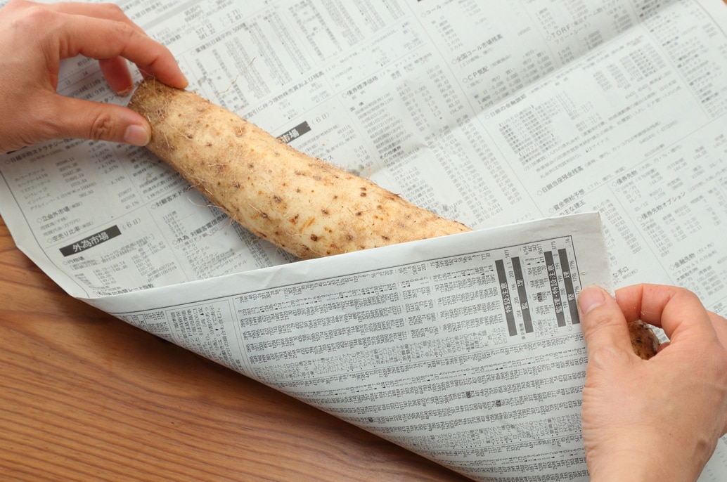 写真：長芋を新聞紙で包む
