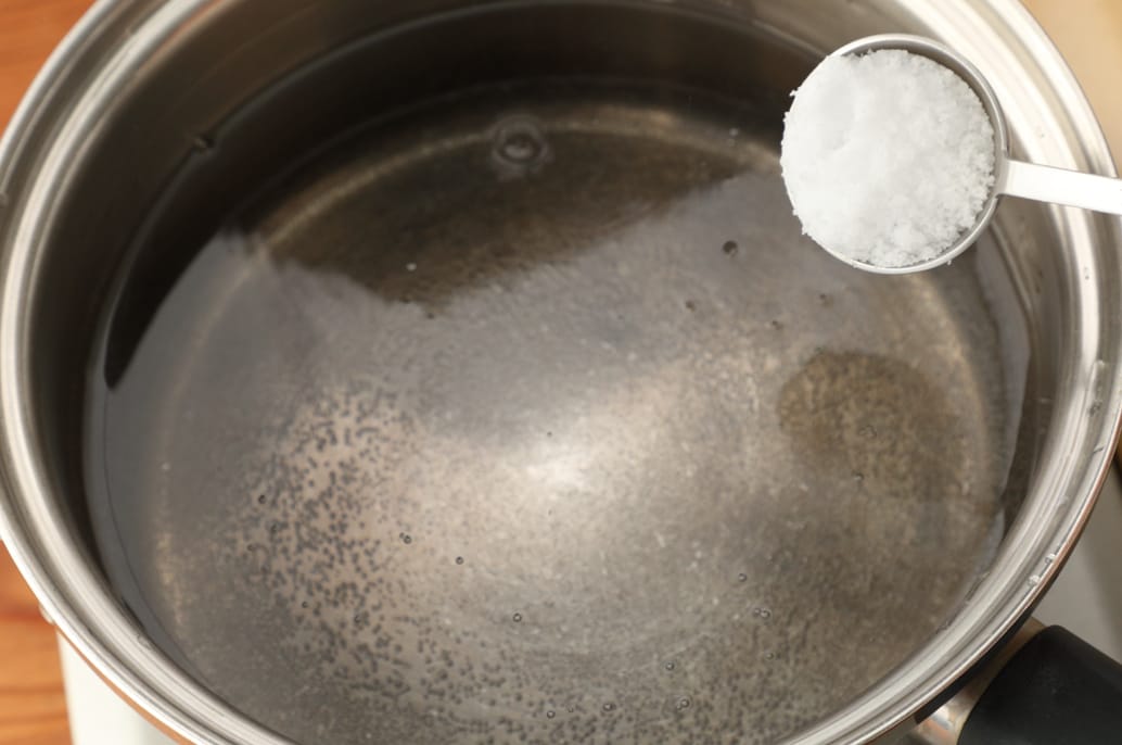 写真：鍋に湯を沸かし、塩を加える