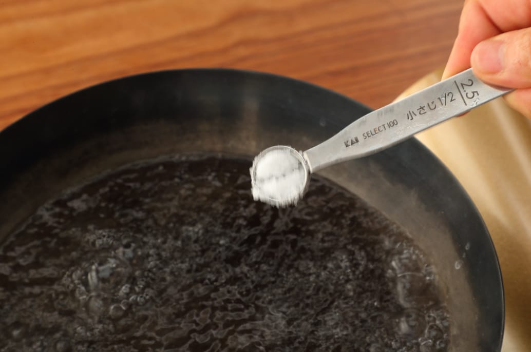 写真：フライパンにお湯を沸かし、塩を加える
