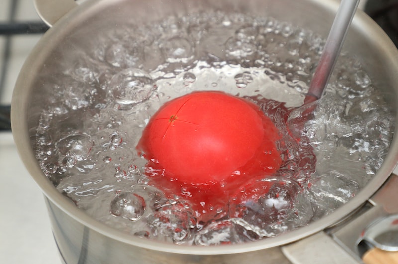 写真:沸騰した湯にトマトを入れる