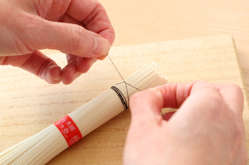 写真：そうめんの束に糸を結ぶ