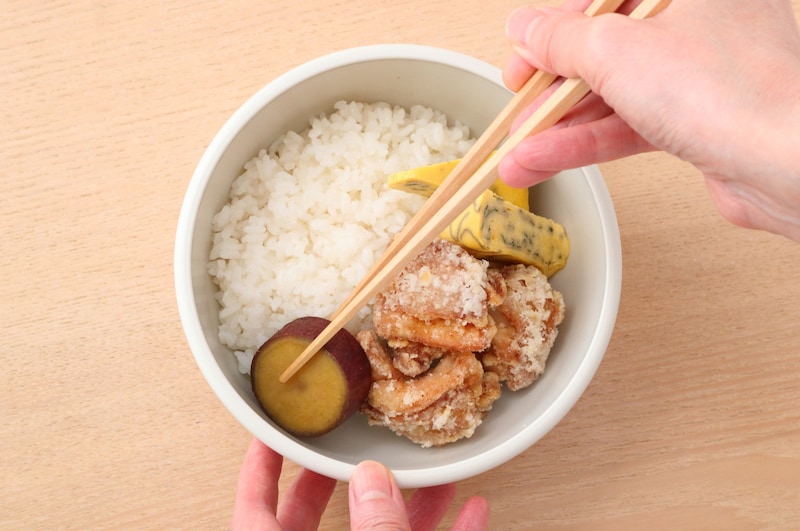 写真：大きいおかずから順に詰めていく